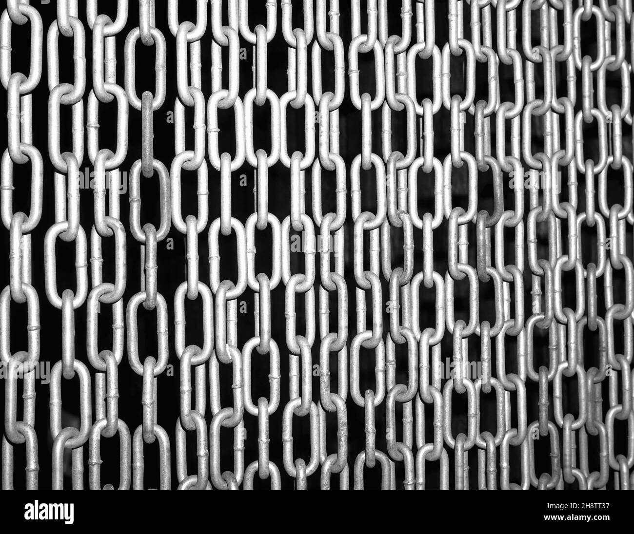 Schwarz-Weiß-Foto mit hohem Kontrast von Ketten auf schwarzem Hintergrund Stockfoto
