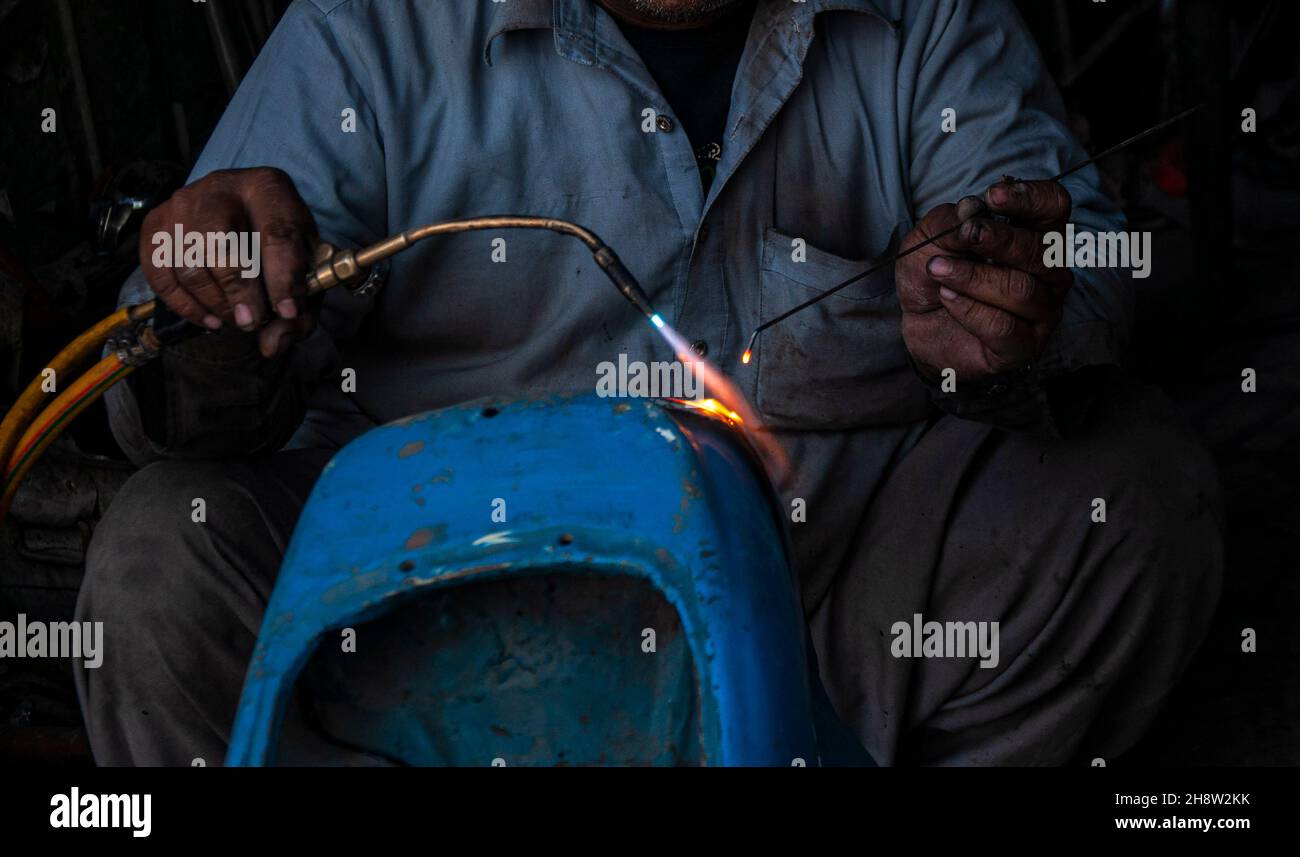 Während die Straßen Pakistans mit billigen chinesischen Motorrädern übersät sind, sind die Liebhaber des seltenen Vespa-Motorrollers auf der Suche nach dem Ersatz-pak Stockfoto