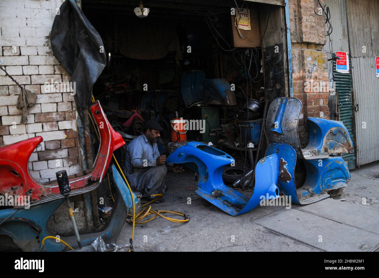 Während die Straßen Pakistans mit billigen chinesischen Motorrädern übersät sind, sind die Liebhaber des seltenen Vespa-Motorrollers auf der Suche nach dem Ersatz-pak Stockfoto