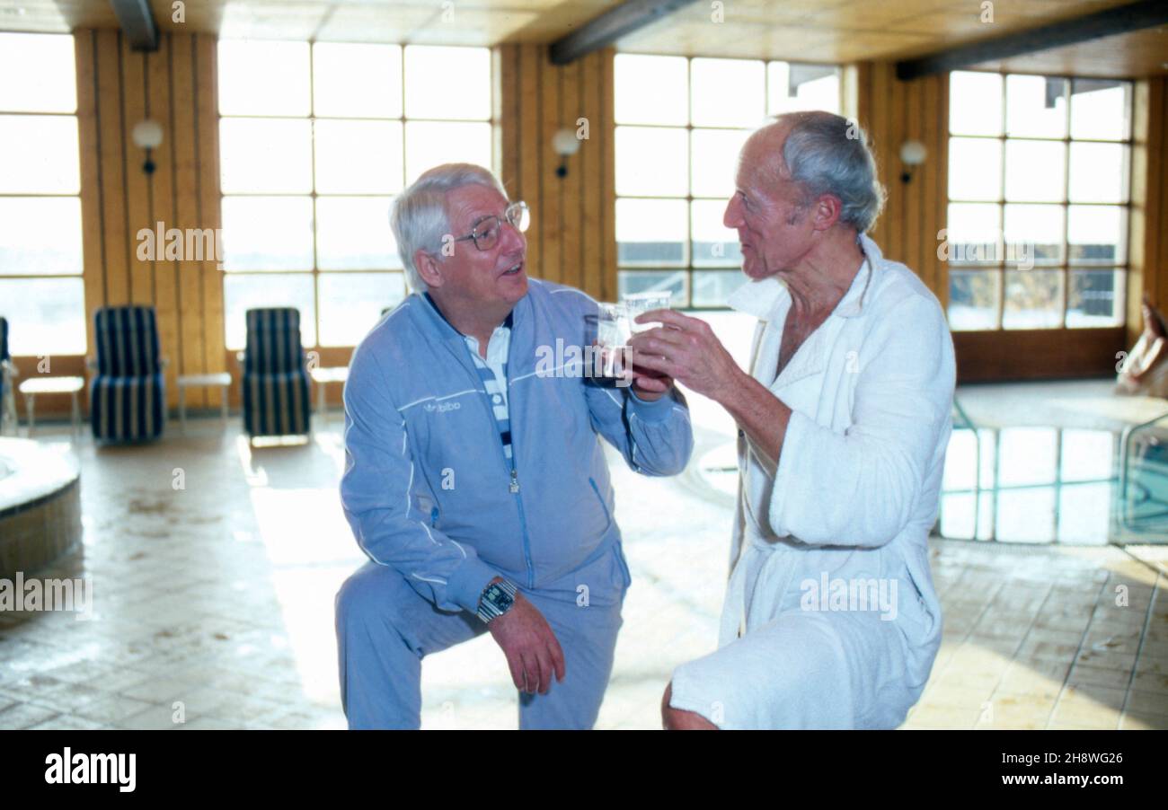 Manfred Köhnlechner, deutscher Verlagsmanager und Heilpraktiker (rechts), bei einem Schluck Heilwasser mit Bundestrainer Jupp Derwall in Griesbach, Deutschland 1983. Der deutsche Verleger und Heilpraktiker Manfred Koehnlechner und Trainer der deutschen Fußballnationalmannschaft Jupp Derwall schlürfen bei einem Kurbad in Griesbach, Deutschland 1983. Stockfoto