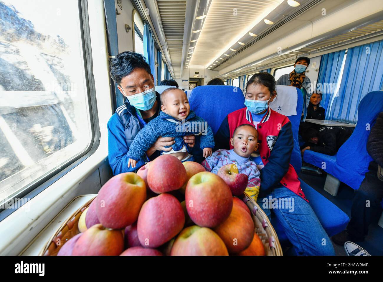 (211202) -- WEINING, 2. Dezember 2021 (Xinhua) -- Eine Familie nimmt den Zug 5647 nach Liupanshui, Stadt im Südwesten Chinas, Provinz Guizhou, 30. November 2021. Im Jahr 2003 wurde der Zug 5648/5647, der die Stadt Zhaotong, südwestlich der chinesischen Provinz Yunnan, mit der Stadt Guiyang, südwestlich der chinesischen Provinz Guizhou, verbindet, in Betrieb genommen. Mit einer Durchschnittsgeschwindigkeit von 40 km/h hält der Zug auf dem Weg an 18 Stationen. Die gesamte Strecke von 407 km dauert 9 Stunden und 31 Minuten. Lokale Dorfbewohner sehen den „Niederzug“ als eine kostengünstige und zuverlässige Möglichkeit, um ihre landwirtschaftlichen Produkte an die Welt außerhalb der zu verkaufen Stockfoto