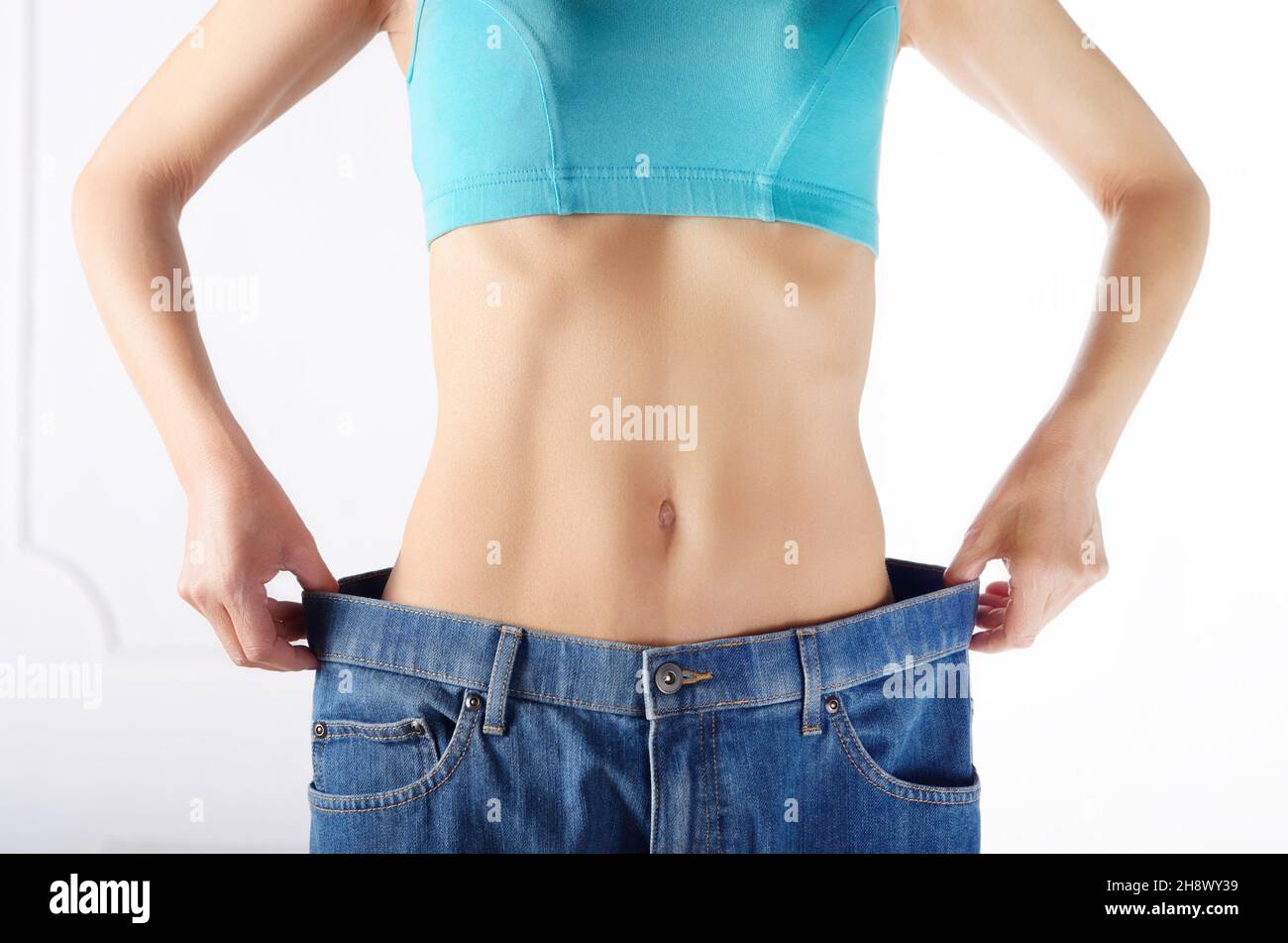 Kaukasische weibliche model in Blue Jeans Ihr flacher Bauch zeigt. Weightloss Konzept. Stockfoto