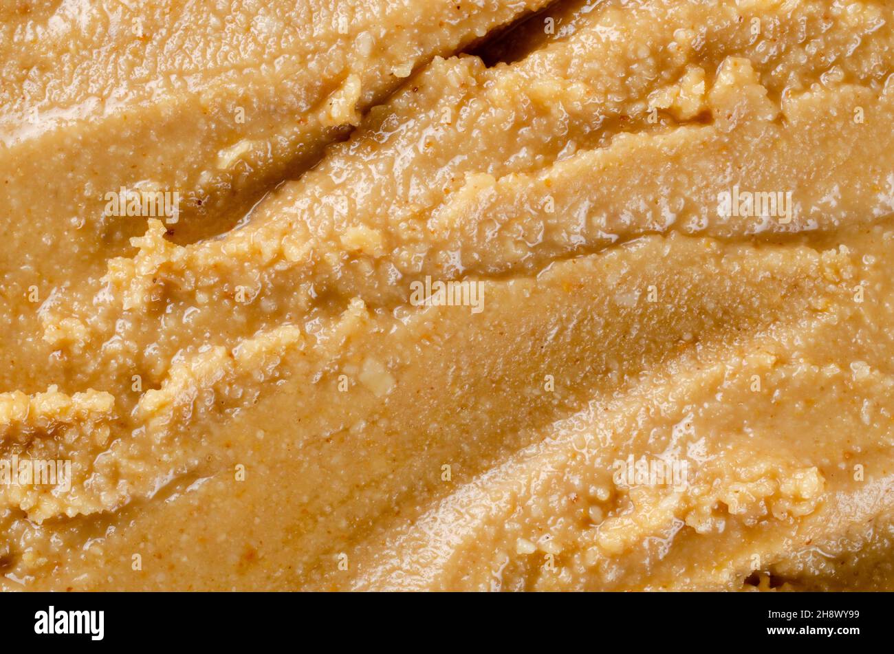 Flache Lage Blick auf frische hausgemachte Erdnussbutter aus gerösteten Erdnüssen, Salz, Honig und Olivenöl Stockfoto