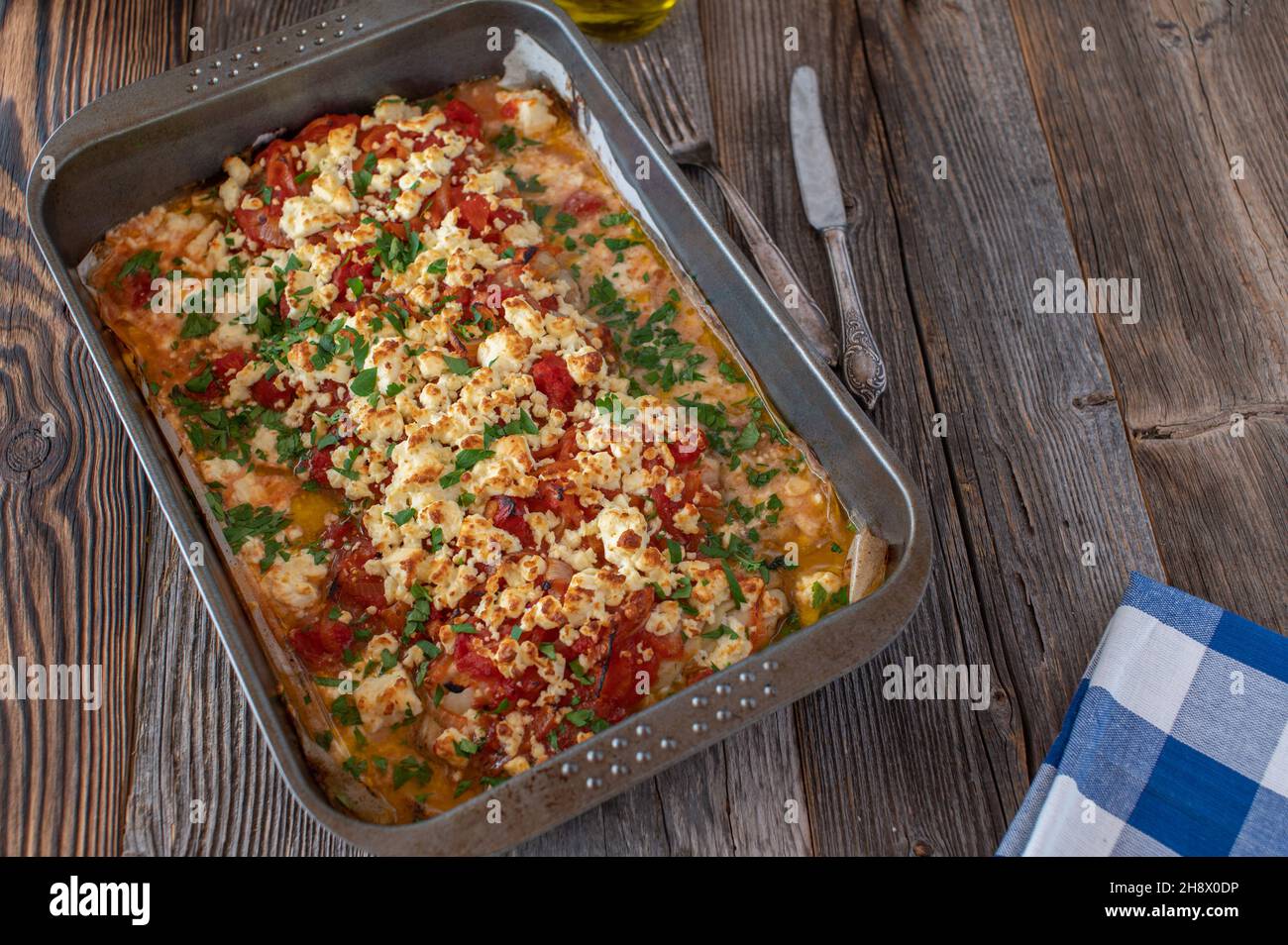Griechisches Fischgericht mit Rotfischfilet, Tomaten, Zwiebeln und Feta-Käse gekocht. Stockfoto