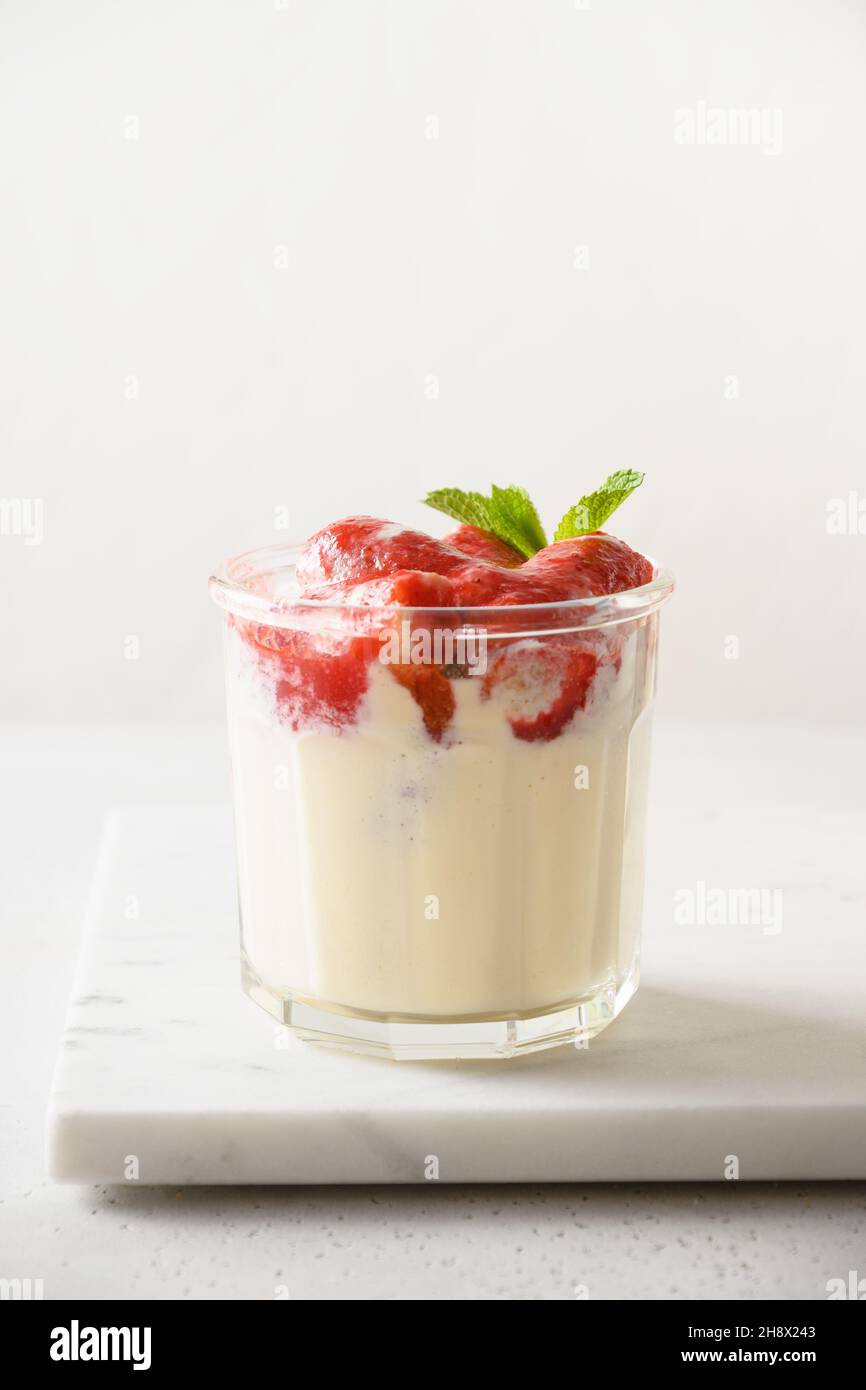 Layered Erdbeere Kleinigkeit Dessert Cookie Savoyardi, Mascarpone und Schlagsahne auf weißem Hintergrund. Vertikale Ausrichtung. Nahaufnahme. Stockfoto