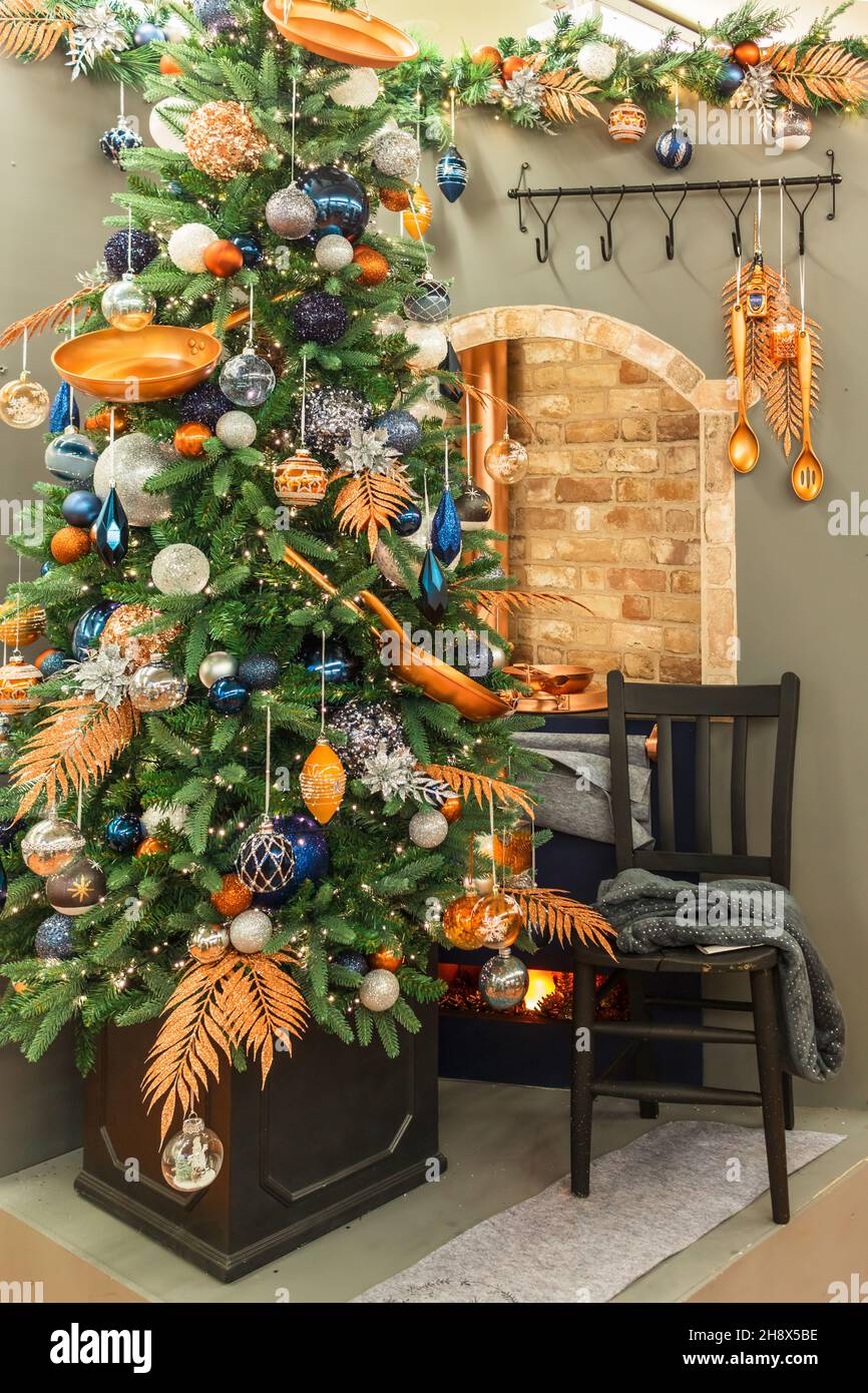 Weihnachtsbaum mit glänzenden Kugeln und Küchenutensilien verziert. Stockfoto