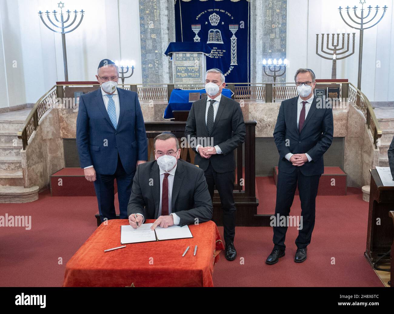 Stuttgart, Deutschland. 02nd Dez 2021. Boris Pistorius, (SPD, Front) Innenminister Niedersachsens, unterzeichnet auf der Herbstkonferenz der Innenminister und Innensenatoren der Länder in einer Synagoge eine „Stuttgarter Erklärung“ gegen Hass und Anstiftung. In der zweiten Reihe stehen Joachim Herrmann, (CSU, l-r) Innenminister von Bayern, Thomas Strobl (CDU), Innenminister von Baden-Württemberg und Hans-Georg Engelke, Staatssekretär im Bundesministerium des Innern für Bau und Inneres. Quelle: Bernd Weißbrod/dpa/Alamy Live News Stockfoto