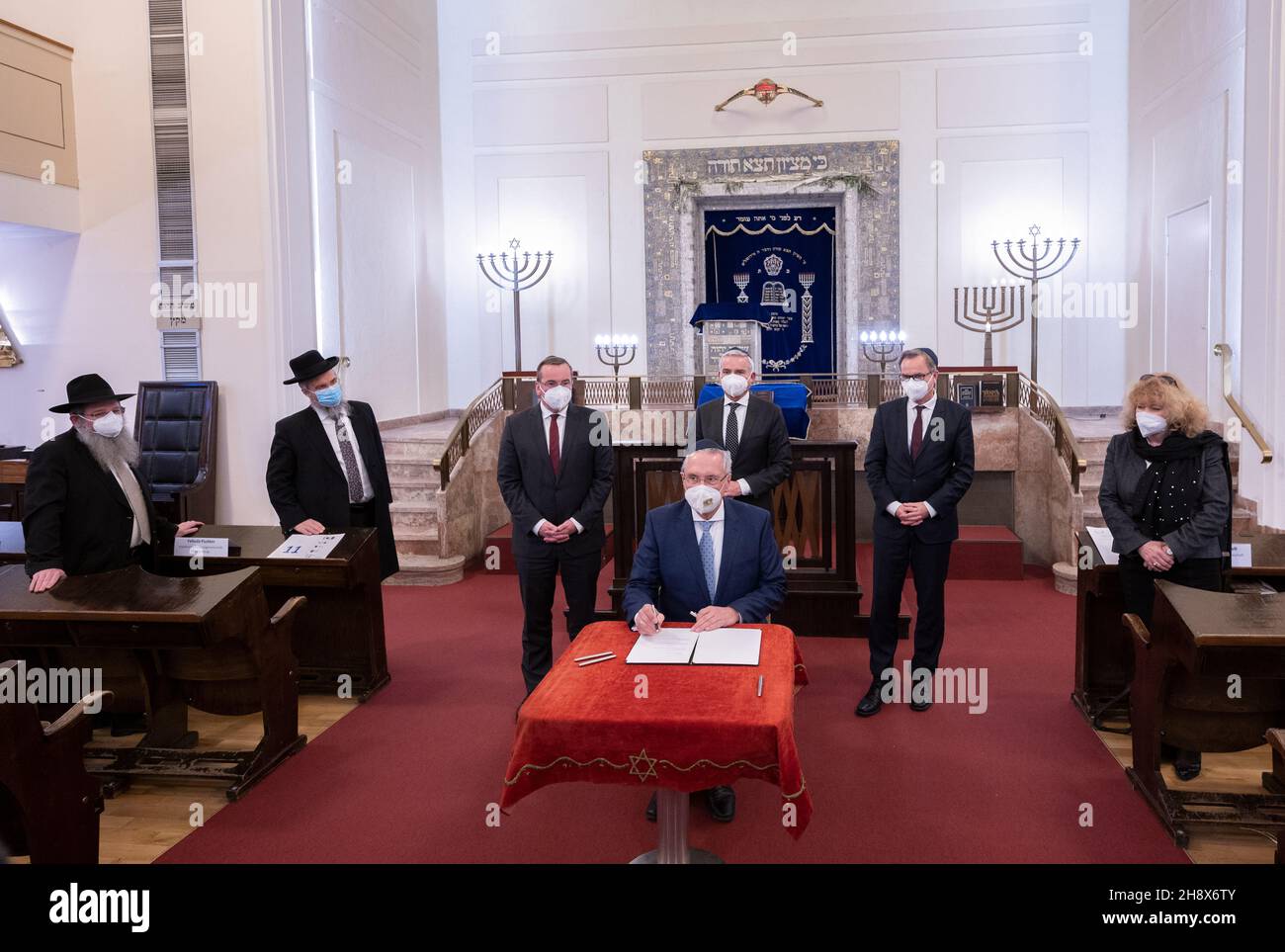 02. Dezember 2021, Baden-Württemberg, Stuttgart: Joachim Herrmann, (CSU, M) Innenminister Bayerns, unterzeichnet auf der Herbstkonferenz der Innenminister und Innenminister der Länder in einer Synagoge eine "Stuttgarter Erklärung" gegen Hass und Anstiftung. In der zweiten Reihe sind Shneur Trebnik (l-r), Polizeirabbiner in Baden-Württemberg, Yehuda Puschkin, Israelitische Religionsgemeinschaft Württemberg, Boris Pistorius, (SPD) Innenminister Niedersachsens, Thomas Strobl (CDU), Innenminister Baden-Württembergs, Hans-Georg Engelke, Staatssekretär im Bundesministerium für Stockfoto