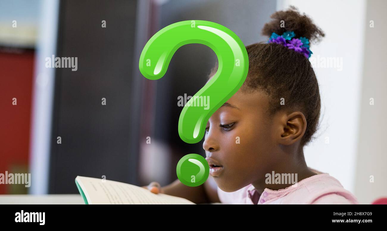 Digitaler Verbund aus grünem Fragezeichen über verwirrten Schulmädchen beim Lesen von Büchern im Klassenzimmer Stockfoto