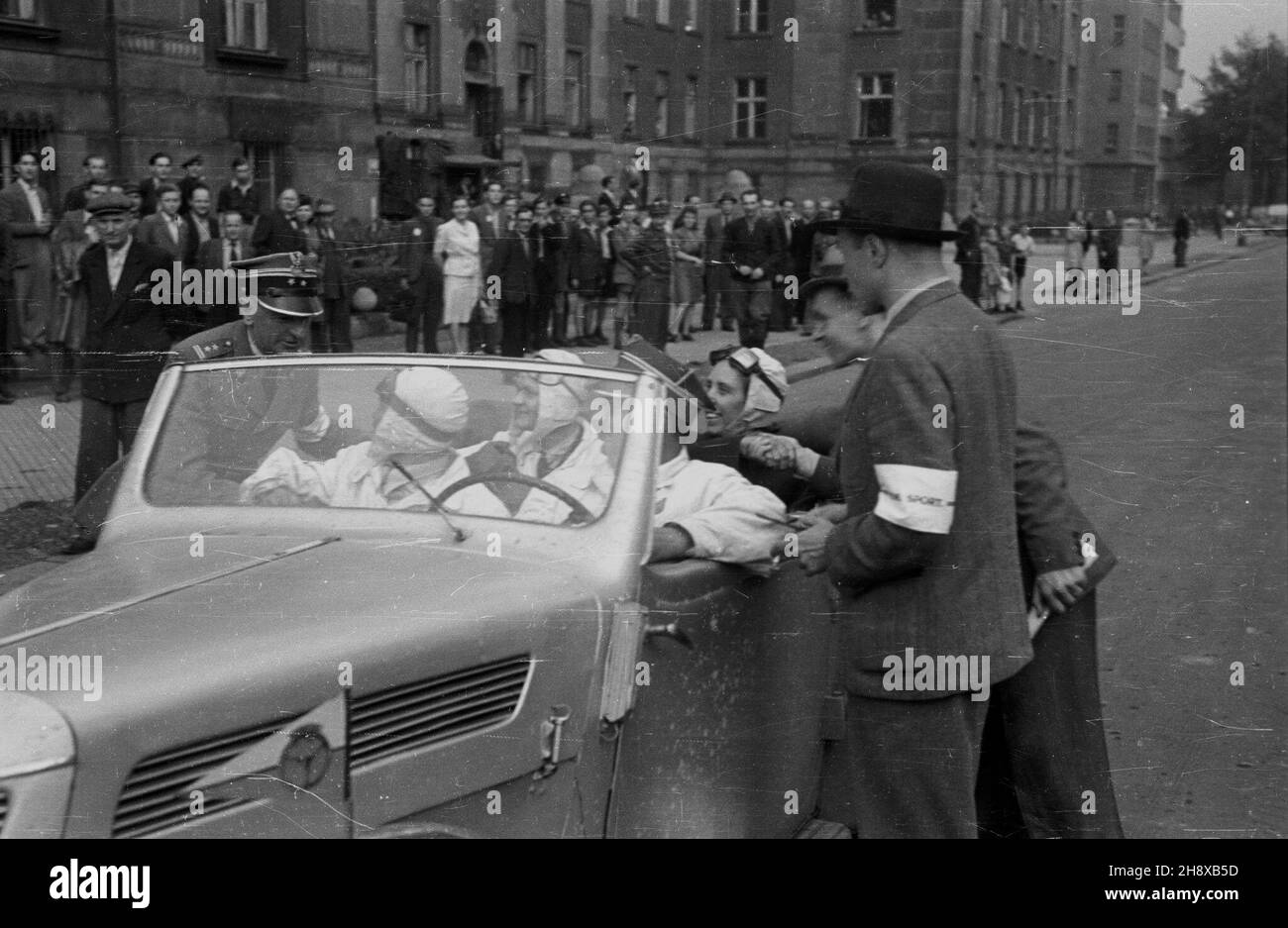 Katowice 1946. Po wojennej przerwie, dziêki staraniom przedwojennych dzia³aczy zostaje reaktywowany Automobilklub Polski. Dziêki nim mog³a byæ kontynuowana dzia³alnoœæ w sportach i turystyce automobilowej. W 1946 roku odby³ siê tradycyjny Rajd Samochodowy AP. NZ. meta rajdu. W g³êbi gmach Sejmu Œl¹skiego. gr PAP/Stanis³aw D¹browiecki Dok³adny miesi¹c i dzieñ wydarzenia nieustalone. Katowice 1946. Nach dem Ausbruch des Krieges wurde der Auto Club Poland aufgrund der Bemühungen von Aktivisten aus der Vorkriegszeit wieder aktiviert. Dank ihnen konnten der Autosport und der Autotourismus in Polen fortgesetzt werden. Eine traditionelle Kundgebung der Stockfoto