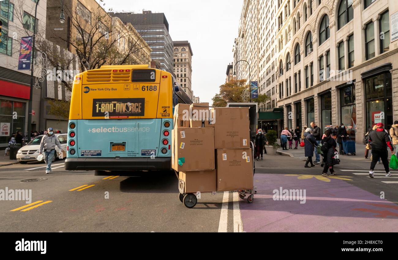 Ein FedEx-Deliveryman mit seinem Wagen, der mit einer bergigen Auswahl an Paketen beladen ist, am Mittwoch, den 1. Dezember 2021, im Viertel Union Square in New York. (© Richard B. Levine) Stockfoto