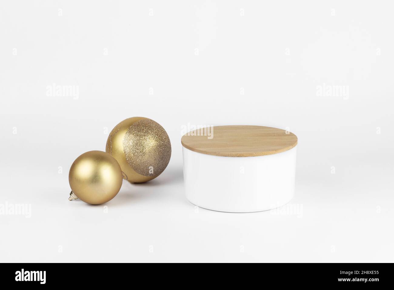Leere runde weiße Podium und goldene Weihnachtskugeln für Produktpräsentation weißen Hintergrund. Minimaler Weihnachts-Kosmetik-Mockup, Kopierplatz. Stockfoto