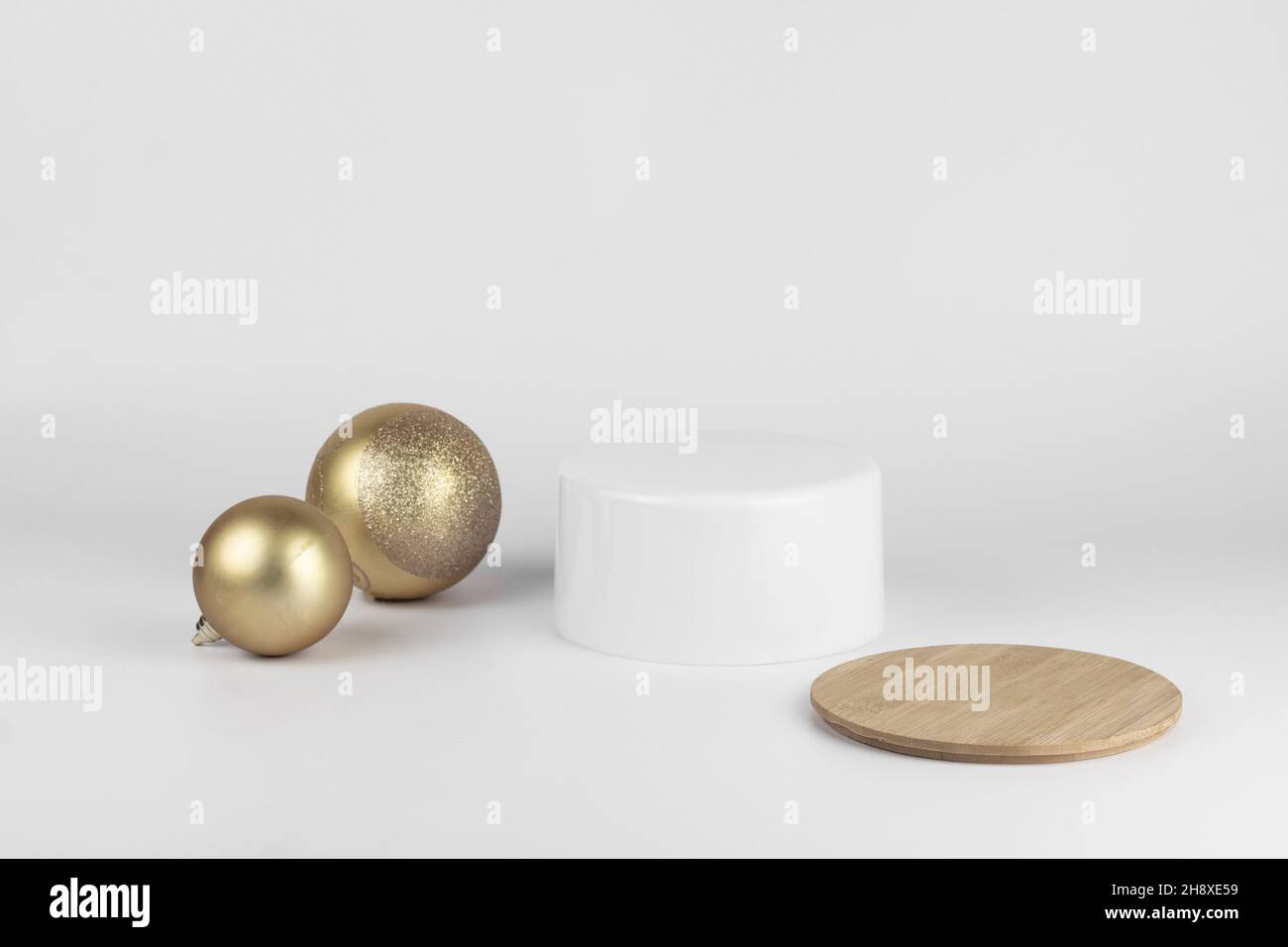 Leere runde weiße Podium und goldene Weihnachtskugeln für Produktpräsentation weißen Hintergrund. Minimaler Weihnachts-Kosmetik-Mockup, Kopierplatz. Stockfoto