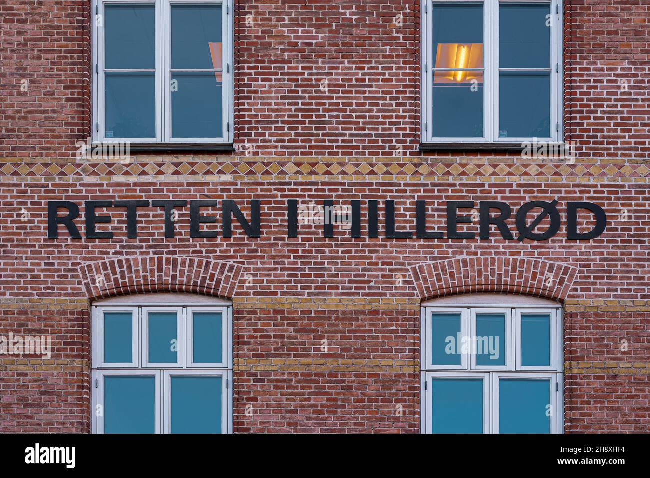Das Gerichtsgebäude in Hillerod und das Schild auf einem roten Ziegelgebäude, Hillerod, Dänemark, 26. November 2021 Stockfoto