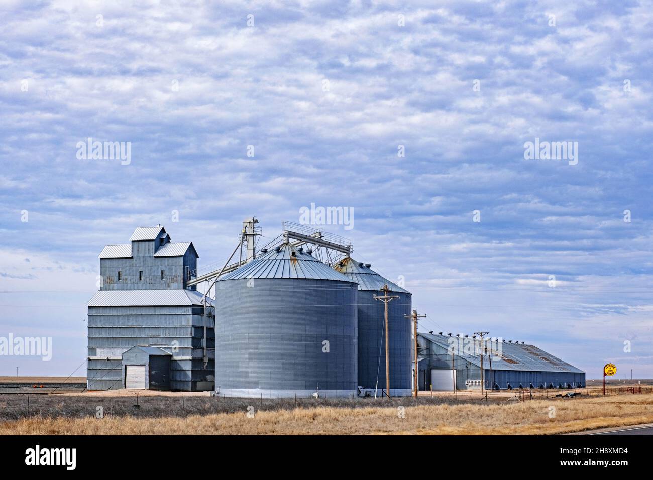 Silos, die mit einem Getreideaufzug auf einer Farm in der Great Plains im Westen von New Mexico, USA/USA verbunden sind Stockfoto