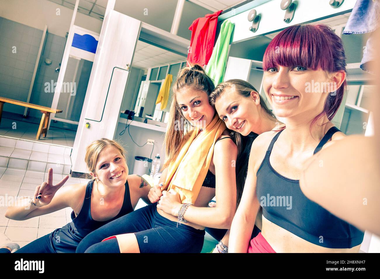 Happy Girlfriends Group nimmt Selfie in Turnhalle Ankleideraum - Sportliche Freundinnen bereit für Fitness-Zeit - gesunde Lebensweise und Sport-Konzept Stockfoto