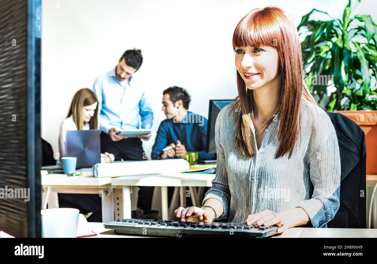 Junge Geschäftsfrau mit Spaß am Computer mit Kollegen bei Büromeeting arbeiten - modernes Start-up-Konzept des Engagements Stockfoto