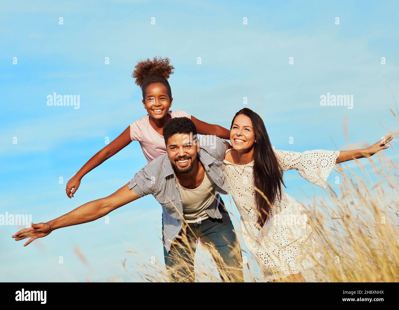 Kind Tochter Familie glücklich Mutter Vater Huckepack Spaß zusammen Mädchen fröhlich Feld im Freien Natur Sommer Stockfoto