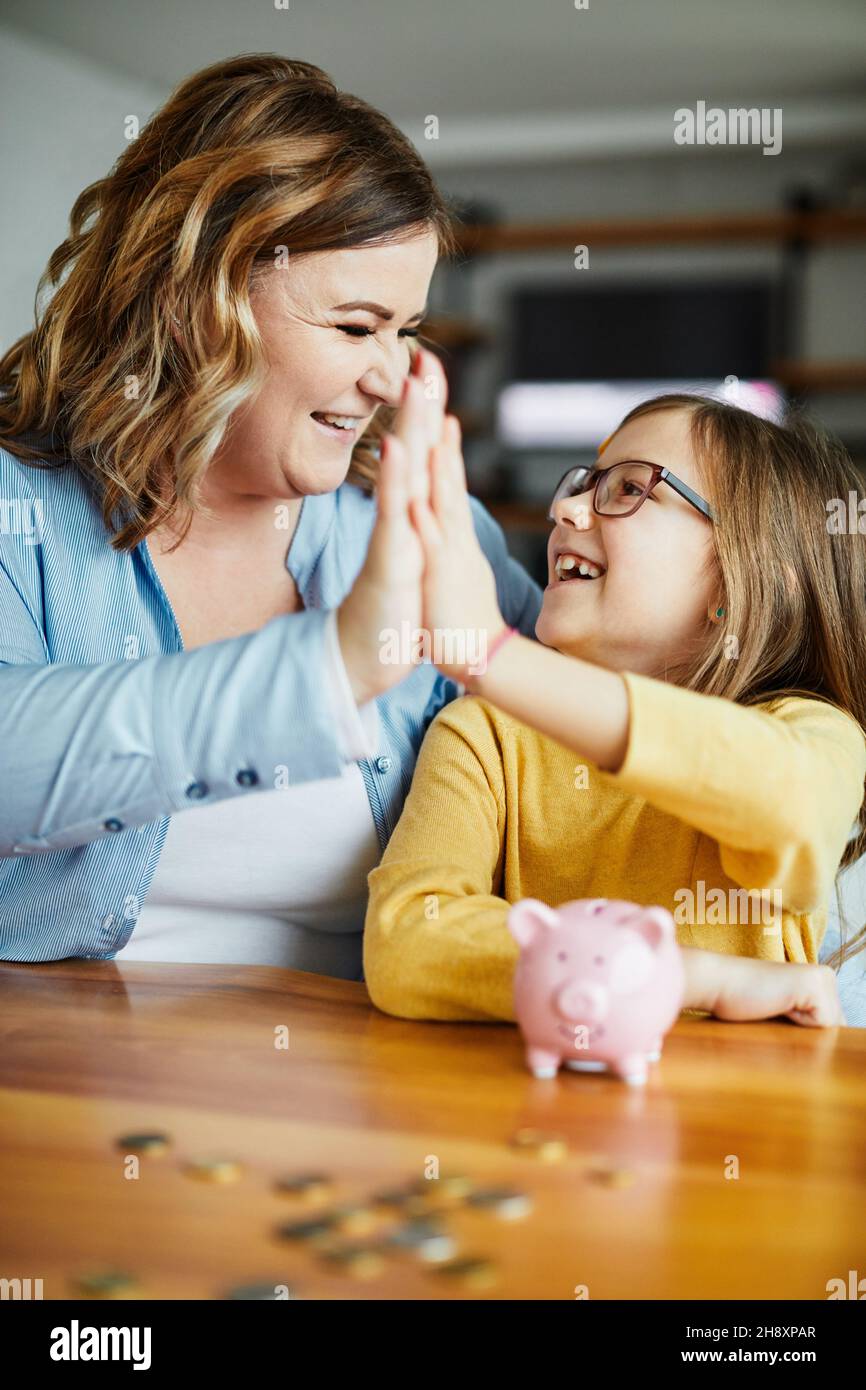 Sparschwein Mutter Tochter Geld sparen Münze finanzieren Kind Familie glückliche Investition Stockfoto