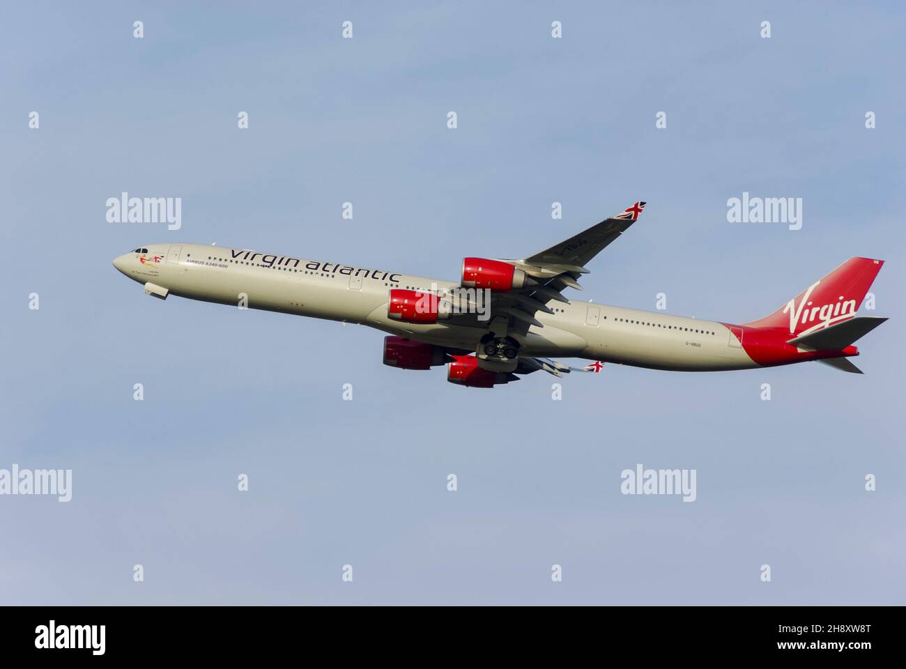 Virgin Atlantic Airbus A340 Airliner Jet-Flugzeug steigt nach dem Start vom London Heathrow Airport, Großbritannien, in den blauen Himmel für Langstreckenflüge Stockfoto