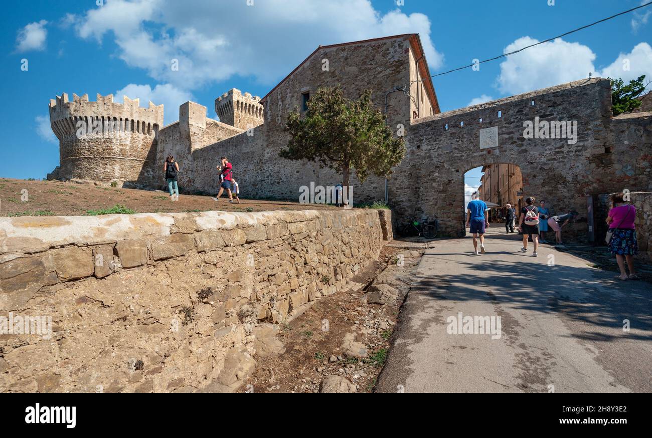 Populonia, Livorno, Italien - 2021, September 18: Menschen, die in dem kleinen Dorf entlang der befestigten Mauern spazieren. Stockfoto