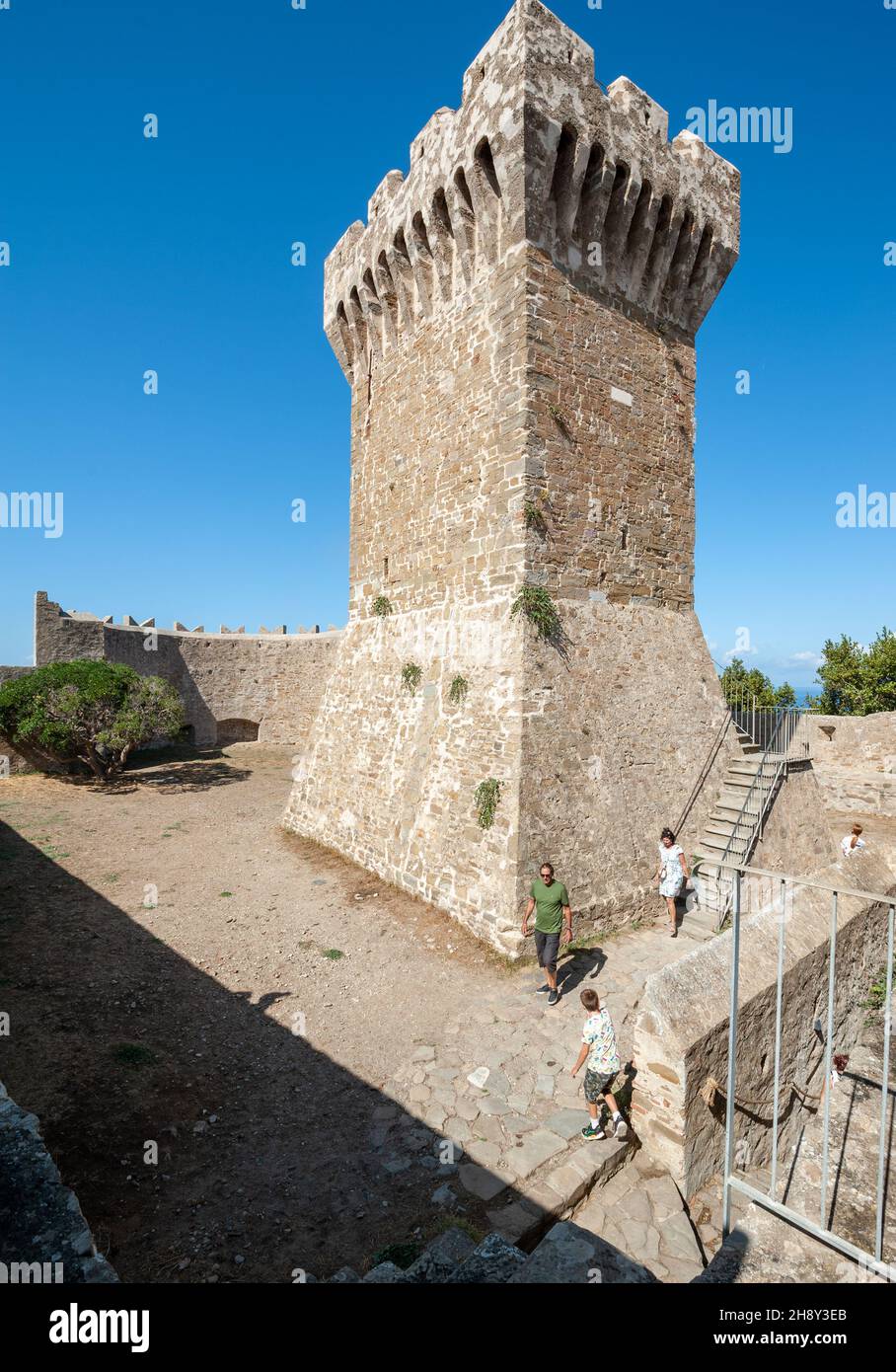 Populonia, Livorno, Italien - 2021, September 18: Besucher der archäologischen Stätte, in der Nähe des alten Wachturms. Stockfoto
