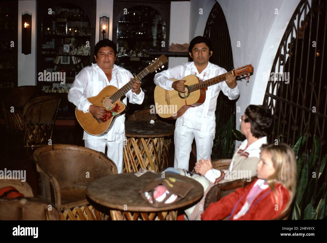 Uxmal, Mexiko. 12/26/1985. Mision Inn. Grand Hotel. Rezeption. Gute Küche. Lokale Sänger mit Gitarrenserene, Cocktail-Lounge-Gäste. Stockfoto