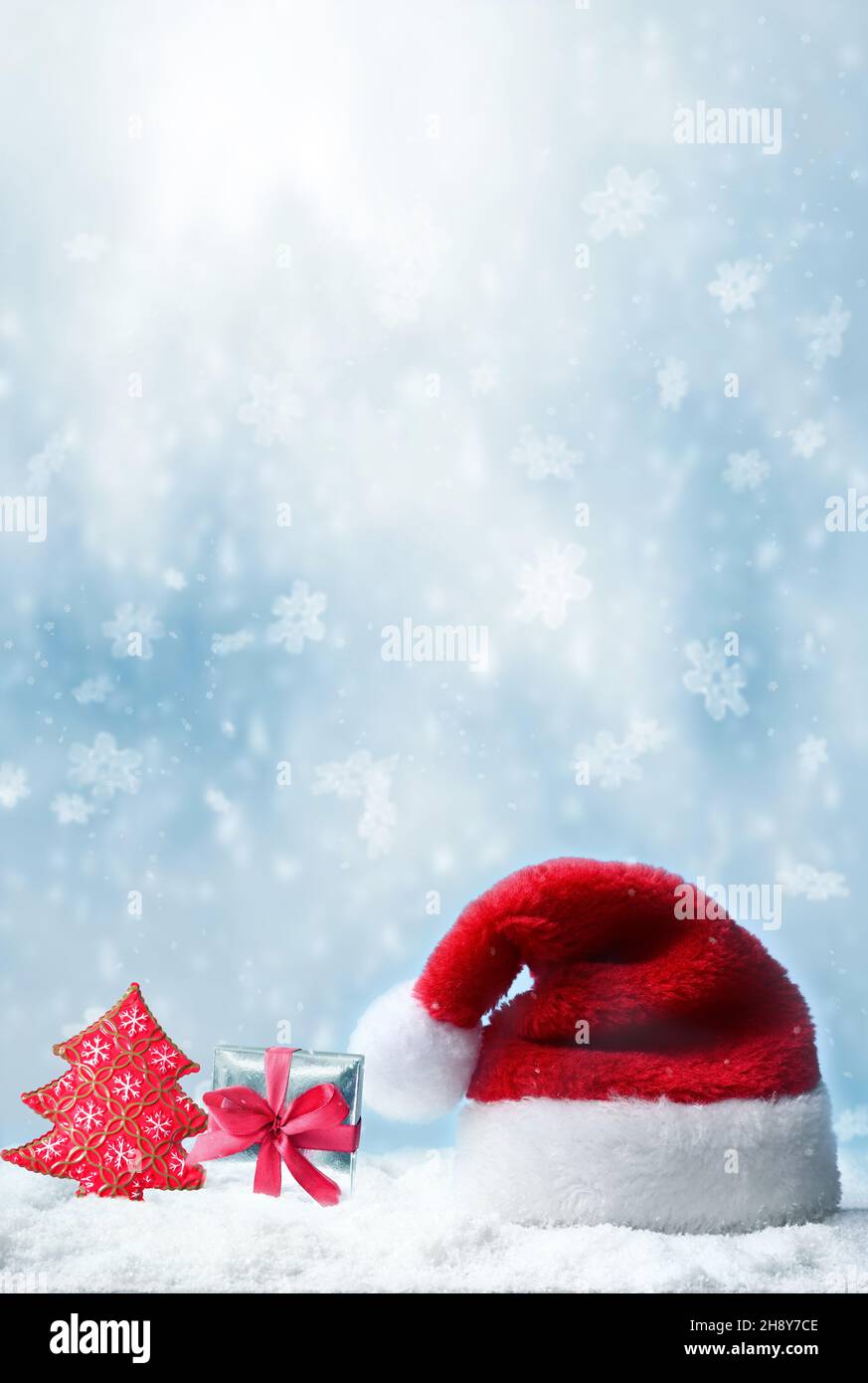 weihnachtsmann Hut mit Schnee und blauem Schneefall Hintergrund. Stockfoto