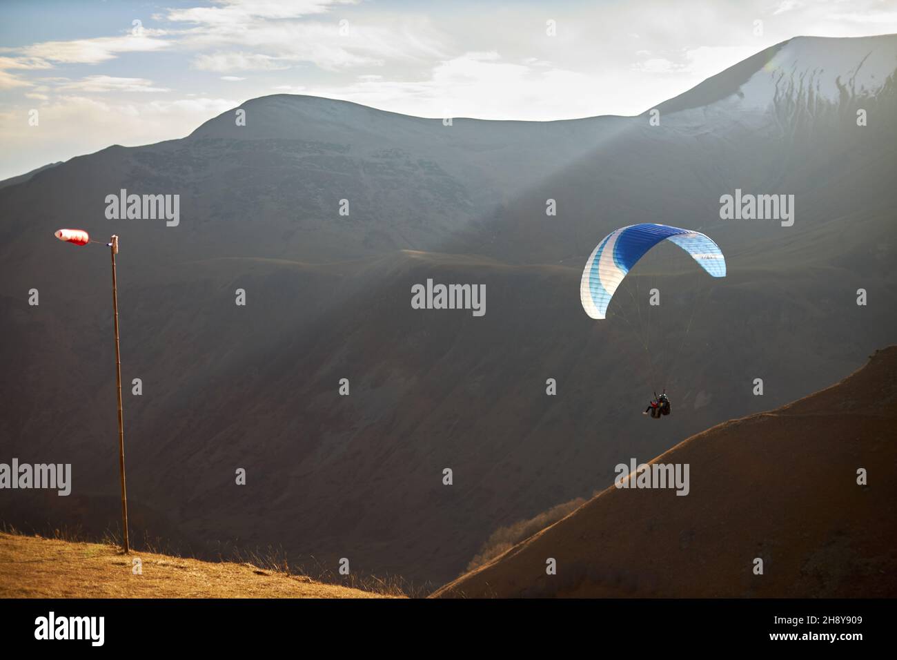 Paragliding Silhouette über Berggipfel. Konzept des aktiven Lebensstils und Extremsportabenteuers Stockfoto