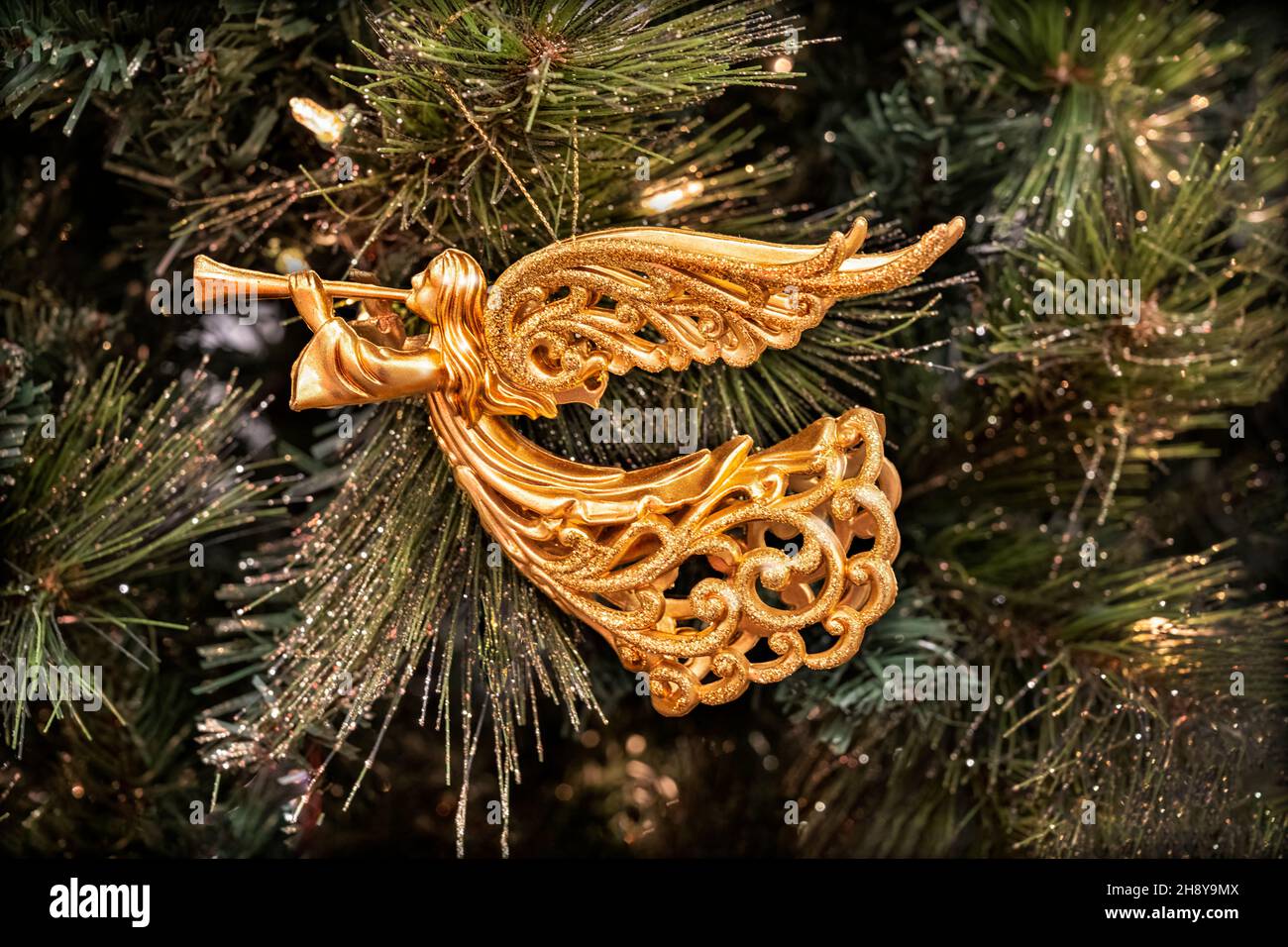Goldenes Weihnachtsornament des Erzengels oder Engels Gabriel, das Horn bläst und an einem Tannenbaum hängt. Gabriel bedeutet '˜Gott ist meine Stärke' oder 'Stärke Gottes'. Stockfoto