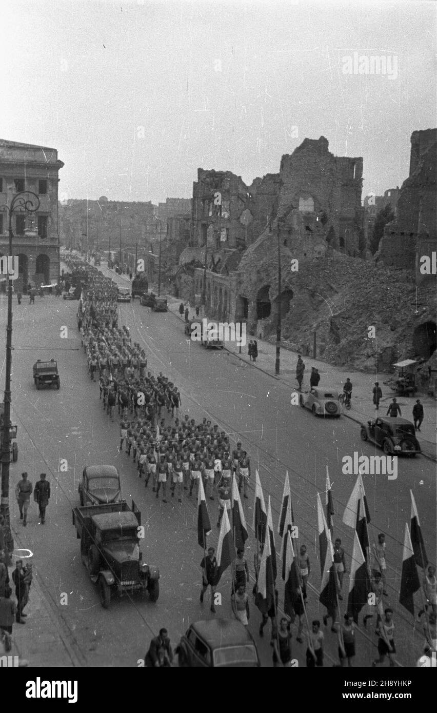 Warszawa, 1946-09-22. Pierwsze po wojnie Igrzyska Sportowe Armii, uczestniczyli w nich ¿o³nierze zawodnicy z ca³ego kraju. O mistrzostwo rywalizowano na stadionie Wojska Polskiego przy ulicy £azienkowskiej. Inauguracjê zawodów poprzedzi³a defilada. Oko³o. 2 tys. zawodników wyruszy³o ze stadionu Wojskowego Klubu Sportowego Legia przy ul. £azienkowskiej, von dotrzeæ na plac Zwyciêstwa. NZ. Sportweste przechodz¹ ulic¹ Krakowskie Przedmieœcie. W g³êbi z lewej ruiny pa³acu Staszica, z prawej zniszczone kamienice. mw PAP/Stanis³aw D¹browiecki Warschau, 22. September 1946. Die 1st nach WW2 Army Sport Stockfoto