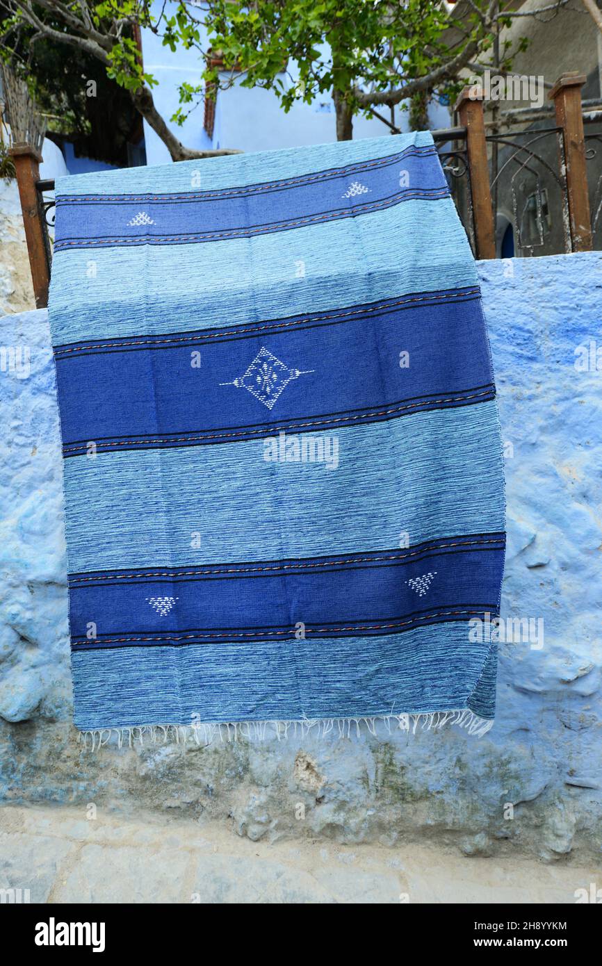 Ein blauer Teppich auf einer blauen Wand in der Medina von Chefchaouen, Marokko. Stockfoto