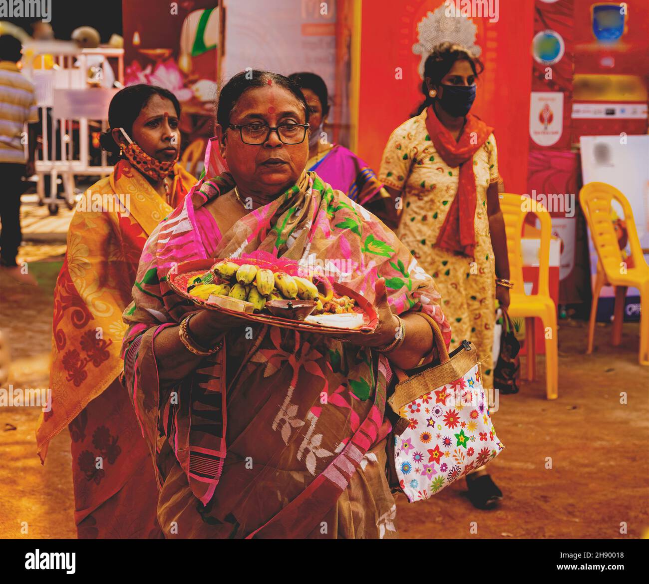 Weibliche Anhängerin, Umzug nach Durga Puja, Pandal, Opfergaben, in ihrer Hand, für, Puja, an die Göttin, Kolkata, Indien Stockfoto