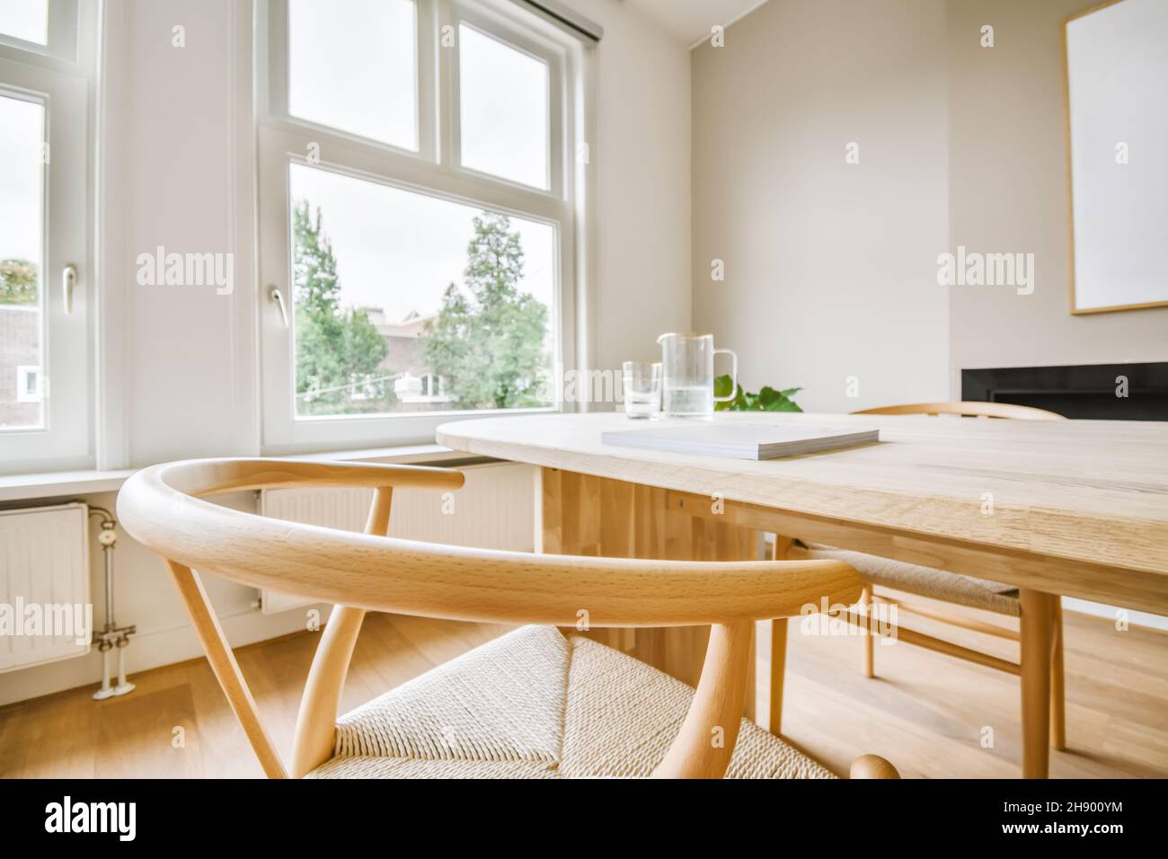 Bequemer Holzstuhl mit einem Tisch am Fenster Stockfoto