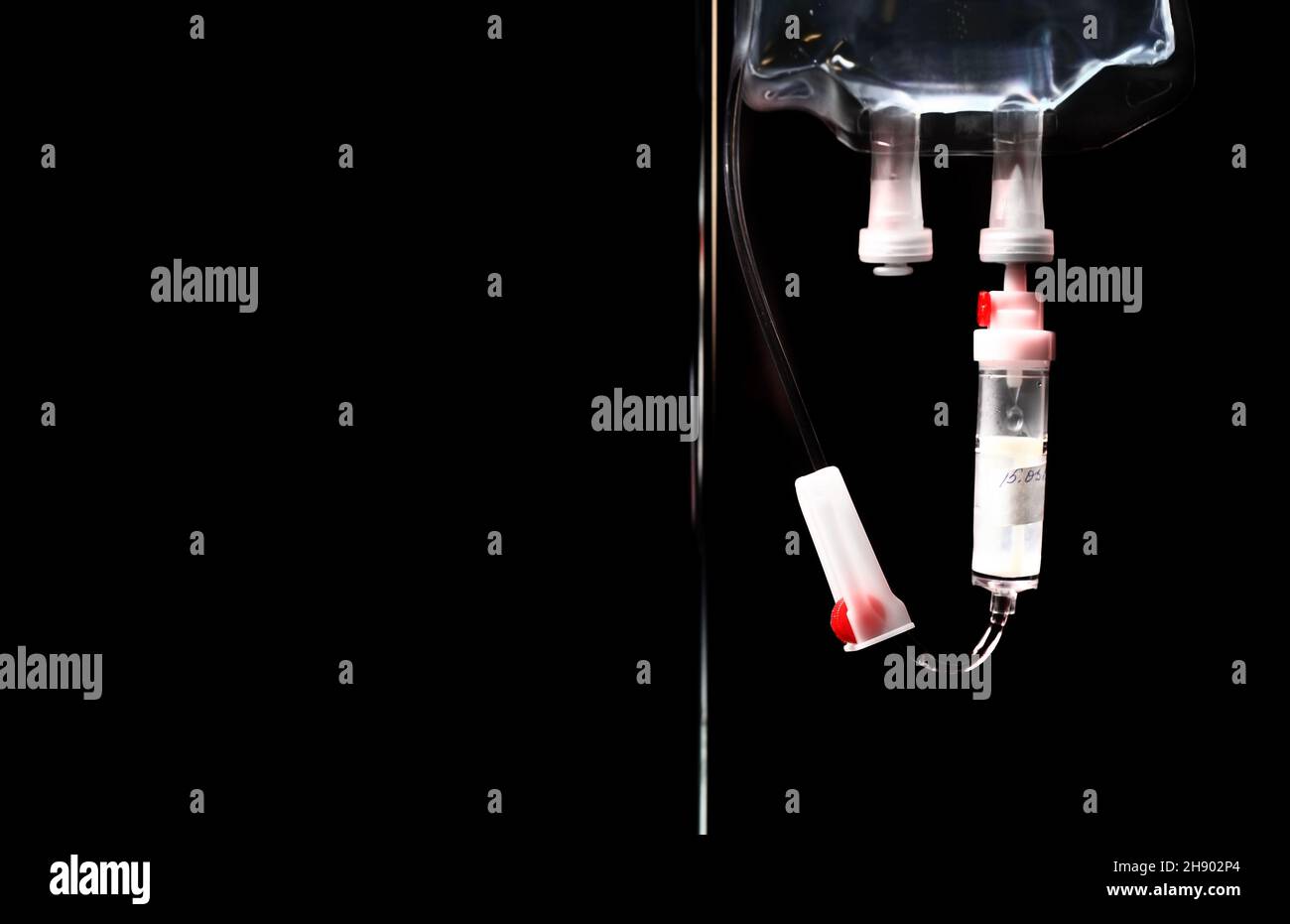 Medizinischer infusionsbeutel auf schwarzem Hintergrund. Stockfoto