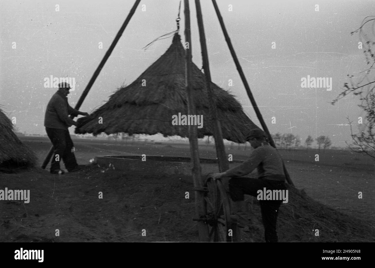 Polska, 1947. Gospodarstwo rolne. Przykrywanie zbiornika na kiszonkê s³omian¹ os³on¹. bb/gr PAP Dok³adny miesi¹c i dzieñ wydarzenia nieustalone. Polen, 1947. Eine Farm. Die Überdachung eines Silagebehälters mit Strohmantel. bb/gr PAP Stockfoto