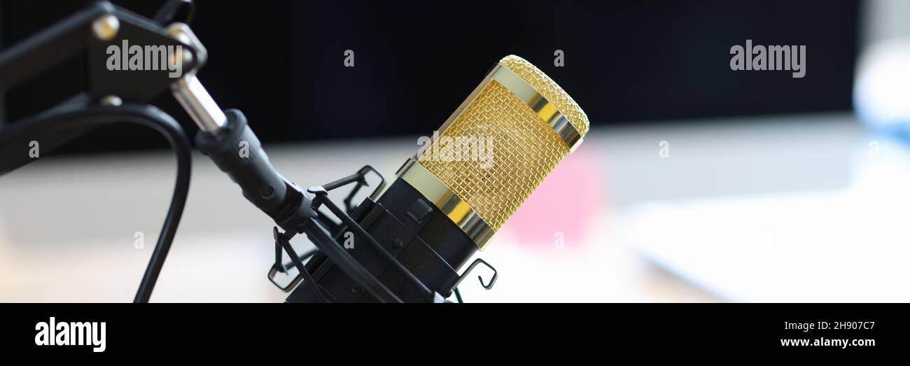 Goldenes Mikrofon, das in Nahaufnahme des Aufnahmestudios auf dem Tisch steht Stockfoto