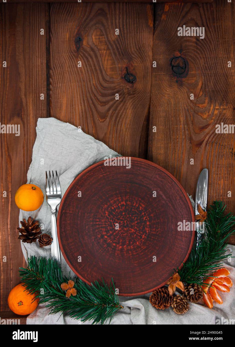 Weihnachten Menü Tisch Einstellung leere Tonplatte Tannenbaum Mandarinen festliche Veranstaltung Dekoration Leinen Tischdecke Geschirr Stockfoto