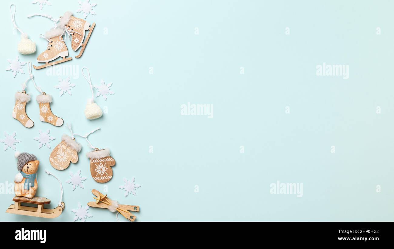 Weihnachtliche Winterkomposition mit Holzdekorationen und einer Spielzeugkatze auf blauem Hintergrund. Flach Lay Draufsicht Kopierer Raum Rahmen Rahmen. Stockfoto
