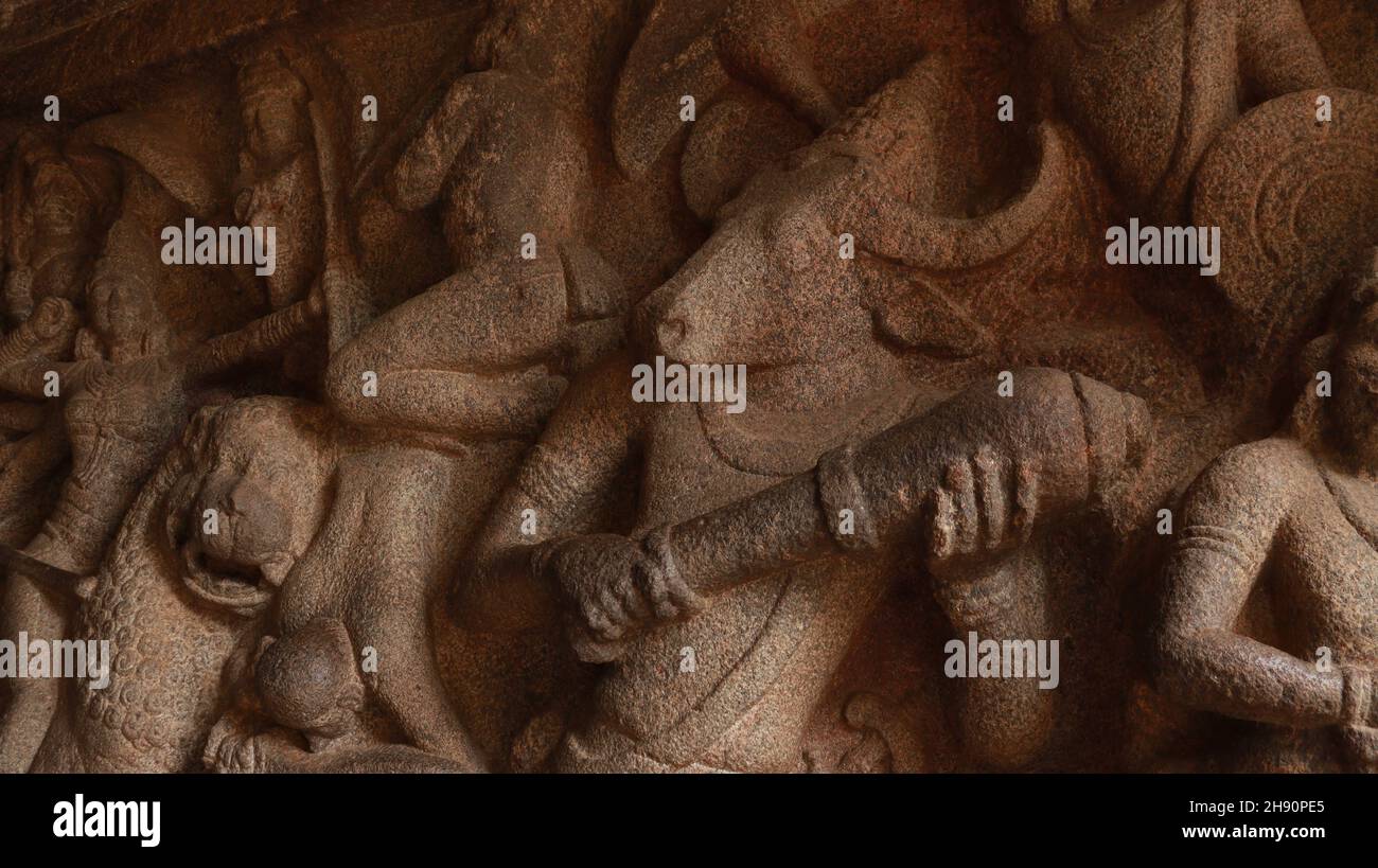 Mahishasurakartini Cave Temple. Steinschnitzereien der Kampfszene von Mahishan und Durga. Das Hotel liegt im Hintergrund des Felsens.Eine Seitenansicht Stockfoto