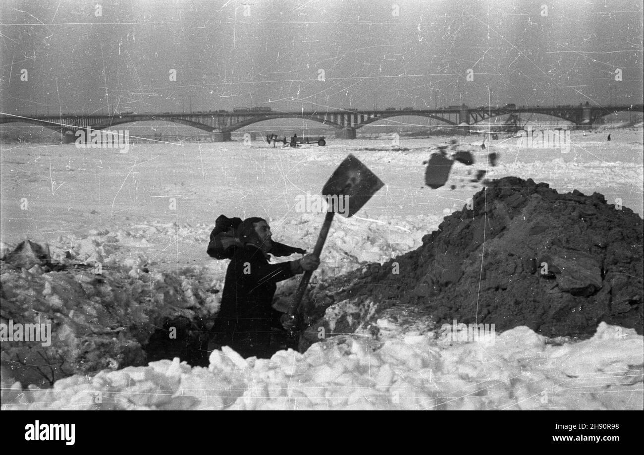 Warszawa, 1947-03. Zabezpieczanie mostu wysokowodnego przed spodziewan¹ wkrótce odwil¿¹ i ruszeniem kry na Wiœle. NZ. Piaskarz wykopuje piasek z mielizny w celu uniemo¿liwienia powstania zatoru przzed izbicami mostu wysokowodnego. W ie meisten Poniatowskiego. wb PAP/Stanis³aw D¹browiecki Dok³adny dzieñ wydarzenia nieustalony. Warschau, März 1947. Die Hochwasserbrücke schützt vor Überschwemmungen angesichts des drohenden Tauwassers und der Eisschollen, die den Fluss hinunter schwimmen. Bild: Sandentfernung zur Vermeidung von Eisstau. Im Hintergrund die Poniatowiski Brücke. wb PAP/Stanislaw Dabrowiecki Stockfoto