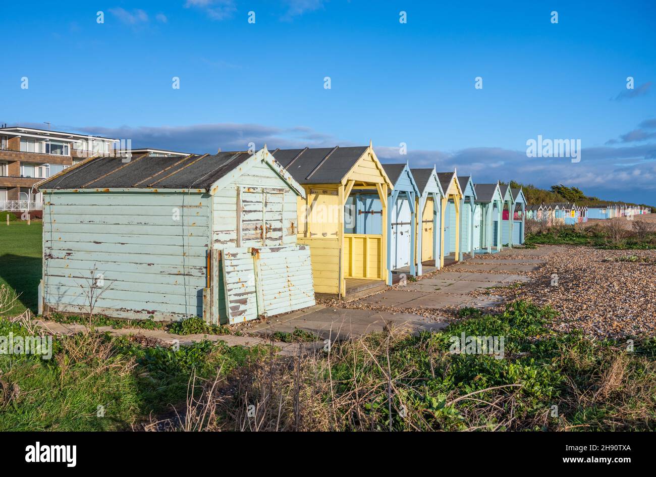 Bunte Holzstrandhütten am Strand entlang der Südküstenküste in Rustington, West Sussex, England, Großbritannien. Stockfoto