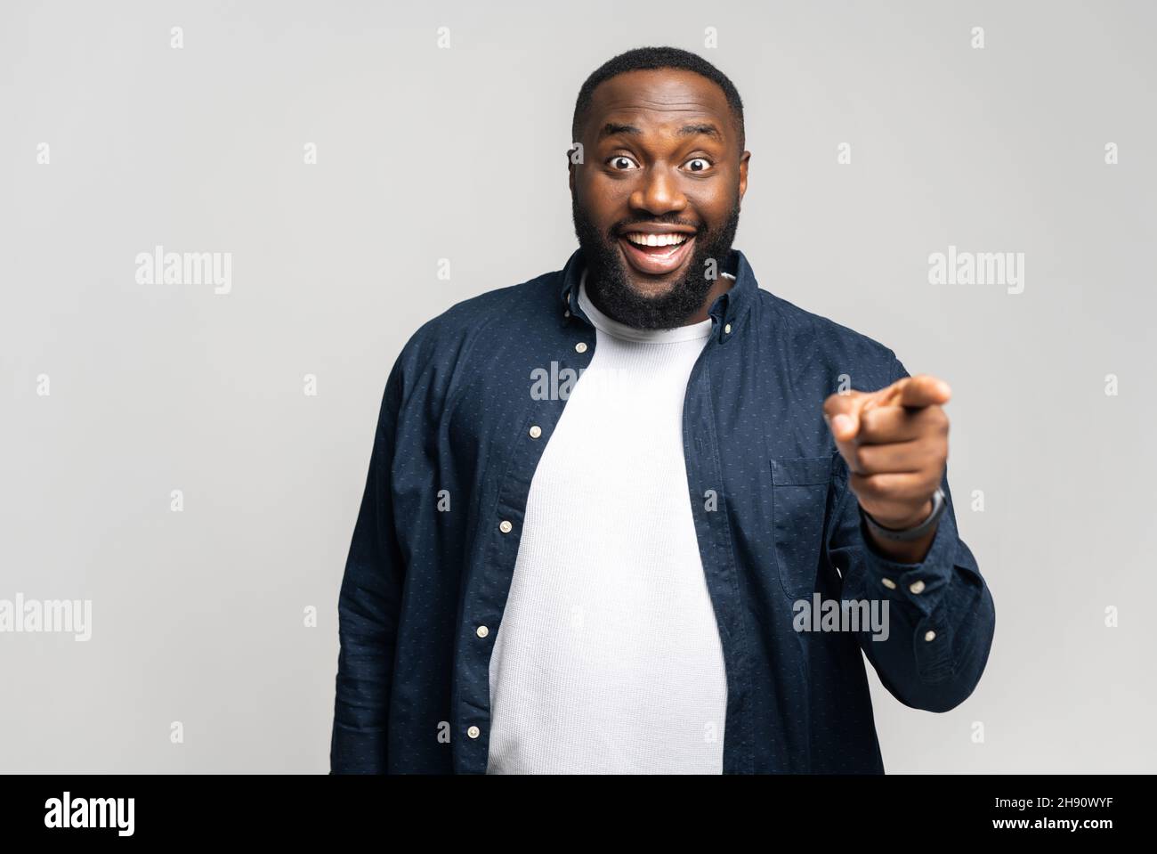 Wir brauchen Sie. Glücklicher Afrikaner, der dich auswählt, mit dem Zeigefinger auf die Kamera zeigt und mit einem fröhlichen Gesicht aufgeregte Chancen oder einen Deal bietet Stockfoto