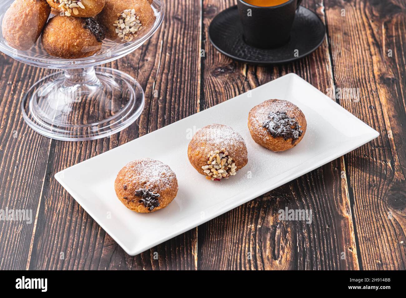 Bombolon oder Bomboloni ist ein italienisches gefülltes Donut- und Snackfutter. Deutsche Krapfen - Krapfen oder berliner - gefüllt mit Marmelade und Schokolade Stockfoto