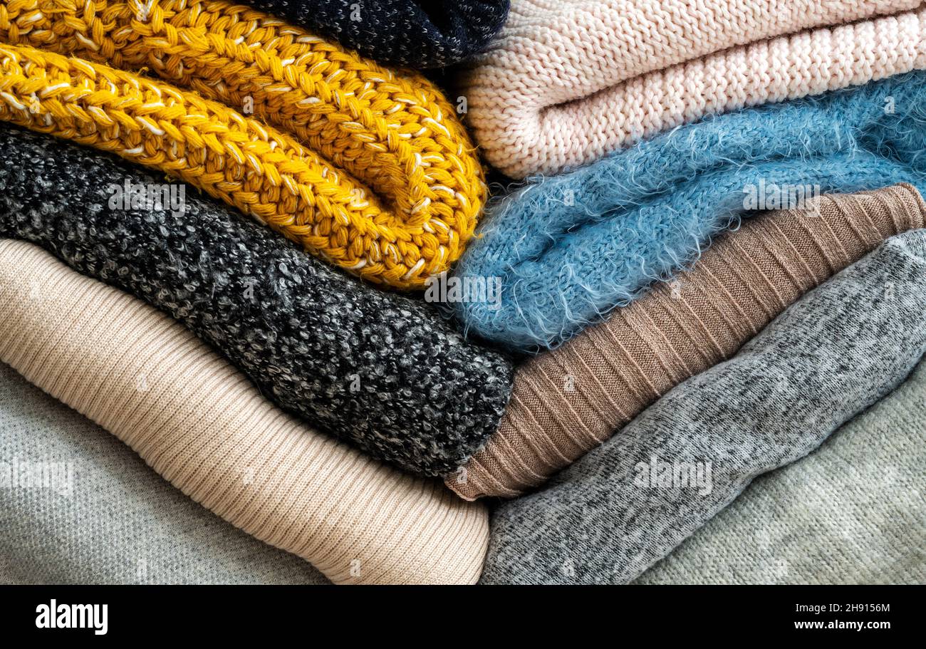 Stapel von Kleidung mit verschiedenen Farben und Materialien. Stockfoto