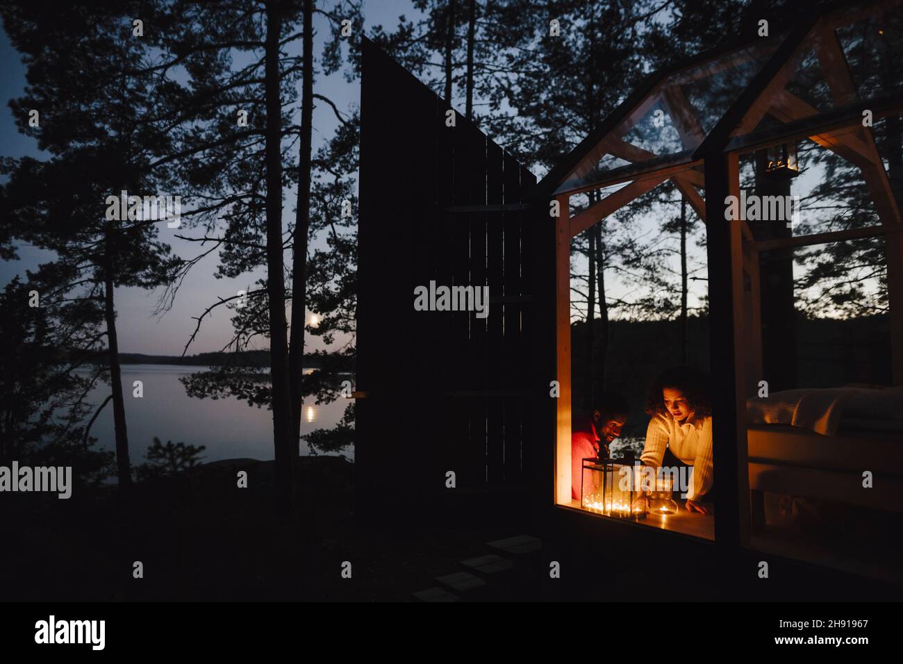 Pärchen schaut sich Kerzen in der Hütte an Stockfoto