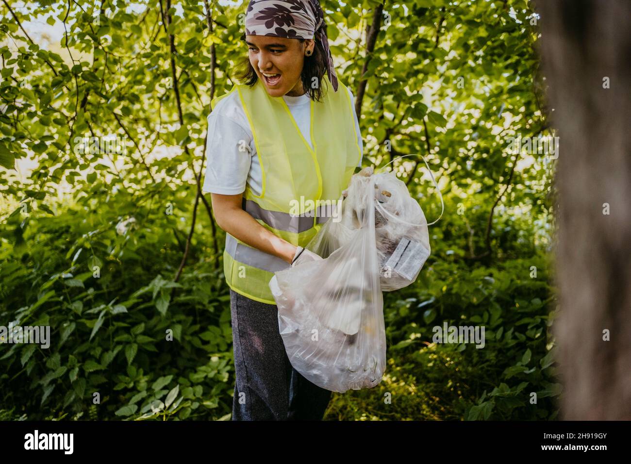 Junge Freiwillige mit offenem Mund sammelt im Park Kunststoffe Stockfoto