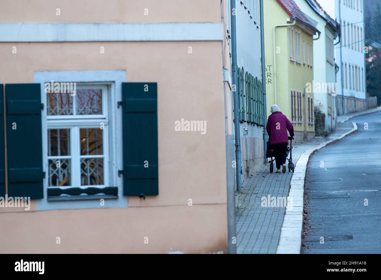 Sachsen, Königstein: 03. Dezember 2021, 03. Dezember 2021, Sachsen, Königstein: Eine ältere Dame geht mit ihrem Spaziergänger am Rathaus vorbei. Der Landkreis Sächsische Schweiz-Osterzgebrige ist derzeit in Deutschland Spitzenreiter bei der Zahl der Fälle von Menschen mit einer Koronaerkrankung. Foto: Daniel Schäfer/dpa-Zentralbild/Daniel Schäfer Stockfoto