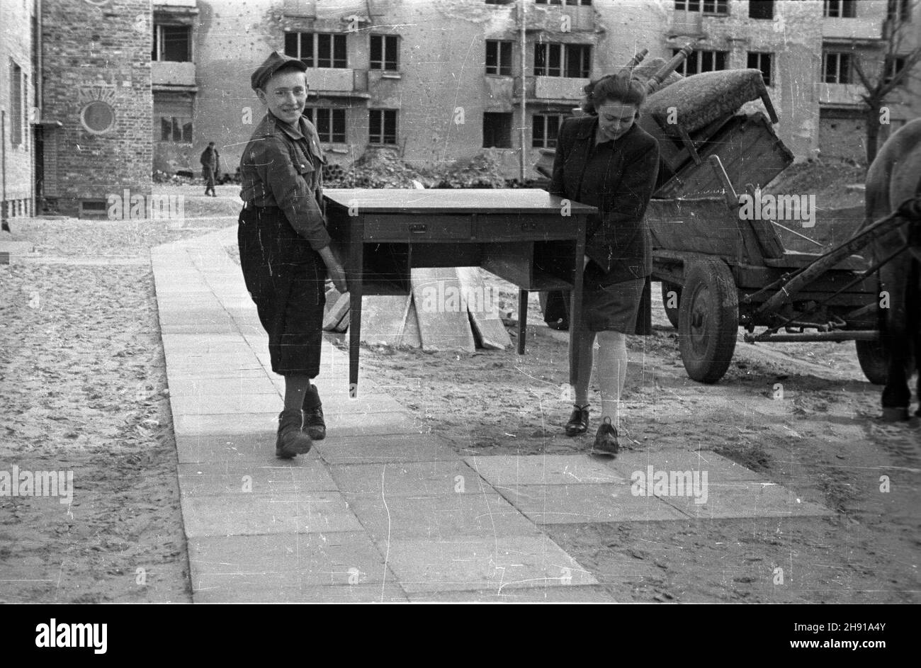 Warszawa, 1947-04. NowI lokatorzy wprowadzaj¹ siê do jednego z bloków XI Kolonii Warszawskiej Spó³dzielni Mieszkaniowej. NZ. Przenoszenie mebli z furmanki do mieszkania. wb PAP/Jerzy Baranowski Dok³adny dzieñ wydarzenia nieustalony. Warschau, April 1947. Neue Mieter ziehen in einen Block der XI Siedlung der Warschauer Wohngenossenschaft. Bild: Möbel von einem Wagen in die Wohnung tragen. wb PAP Stockfoto