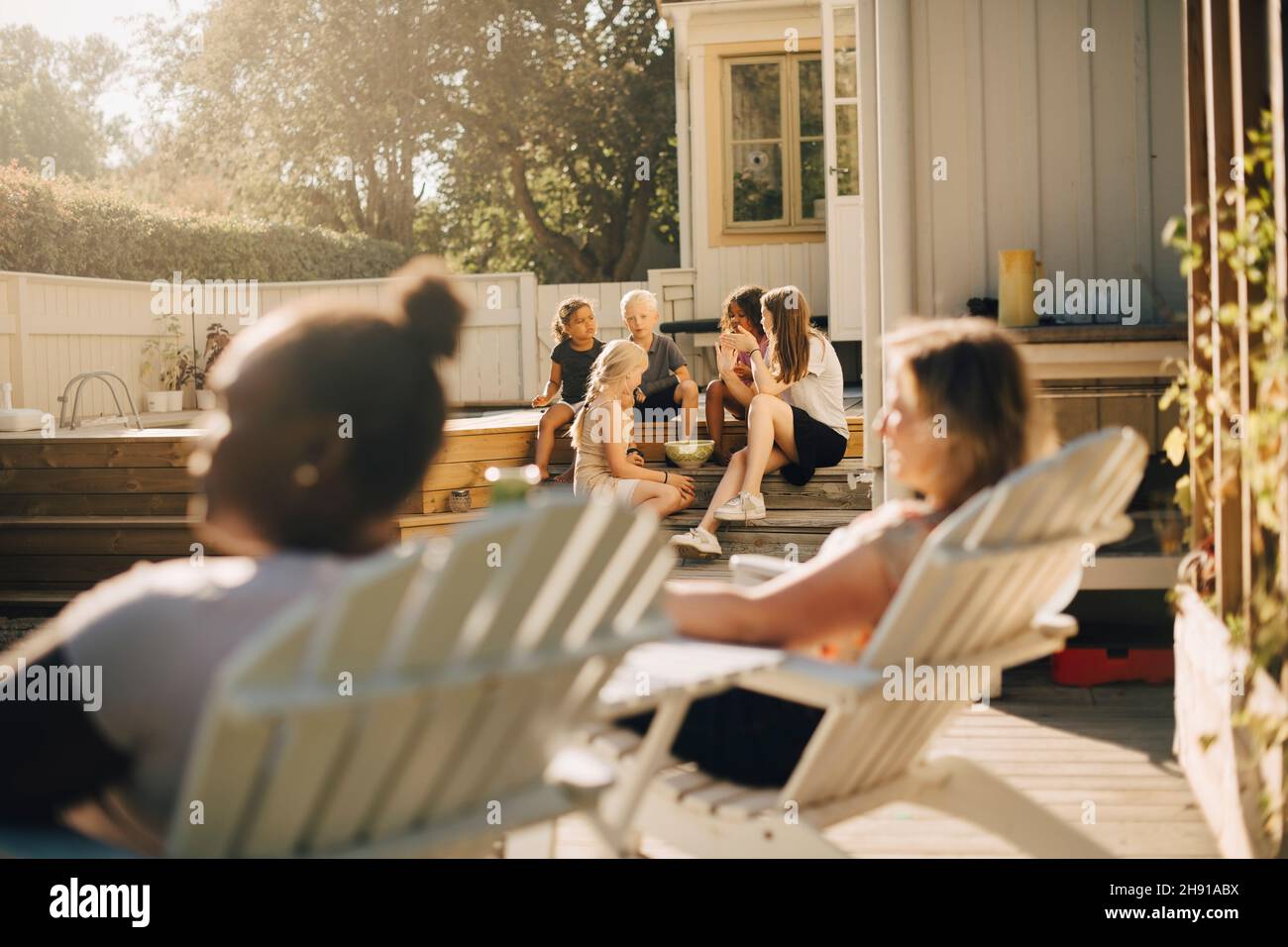Kinder und Mütter verbringen an sonnigen Tagen ihre Freizeit auf der Terrasse Stockfoto